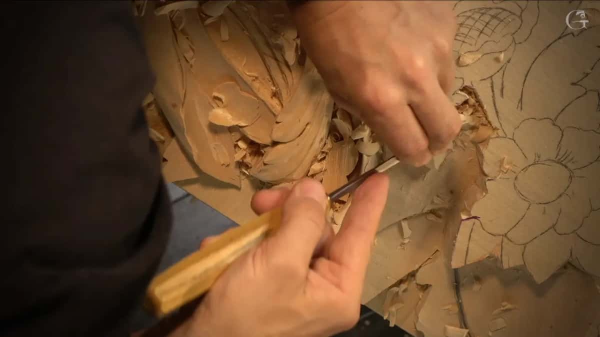 Two hands press one gouge into a leaf.
