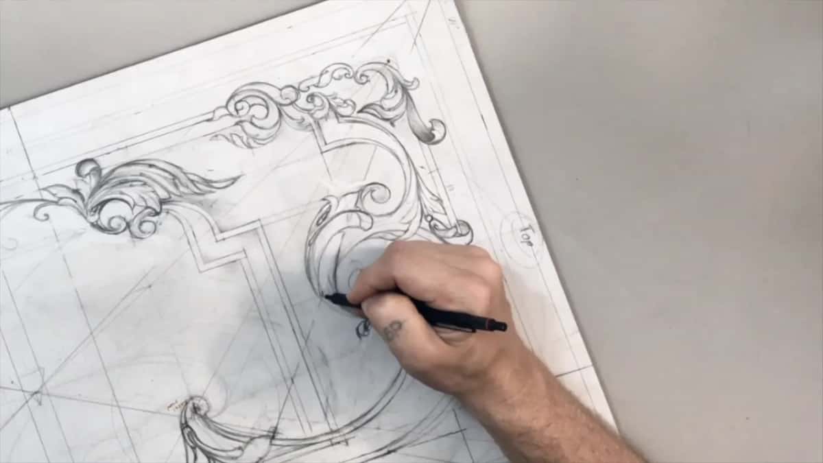 Sheet tilted with Top circled at the right edge and a black pencil working inside a big scroll