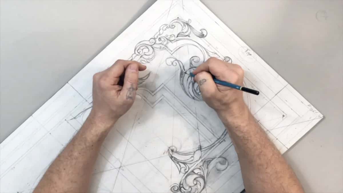 Sheet turned on its corner, a blue pencil drawing a curl while the left hand holds the paper