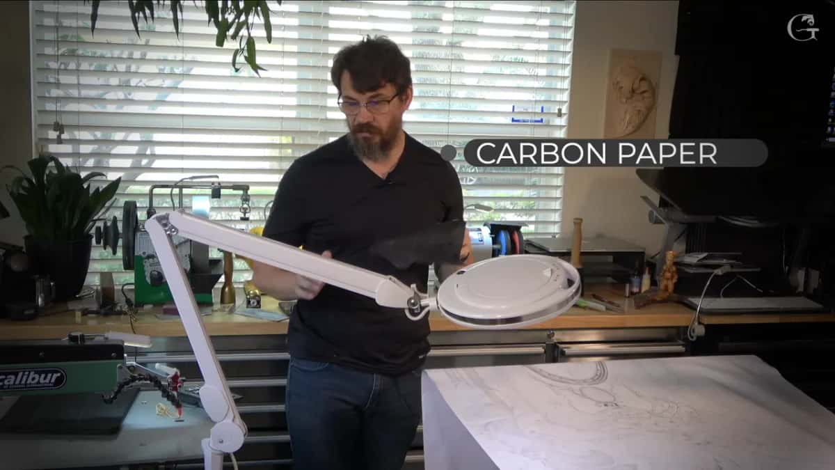 Black carbon sheet held up over the printed pattern on the board