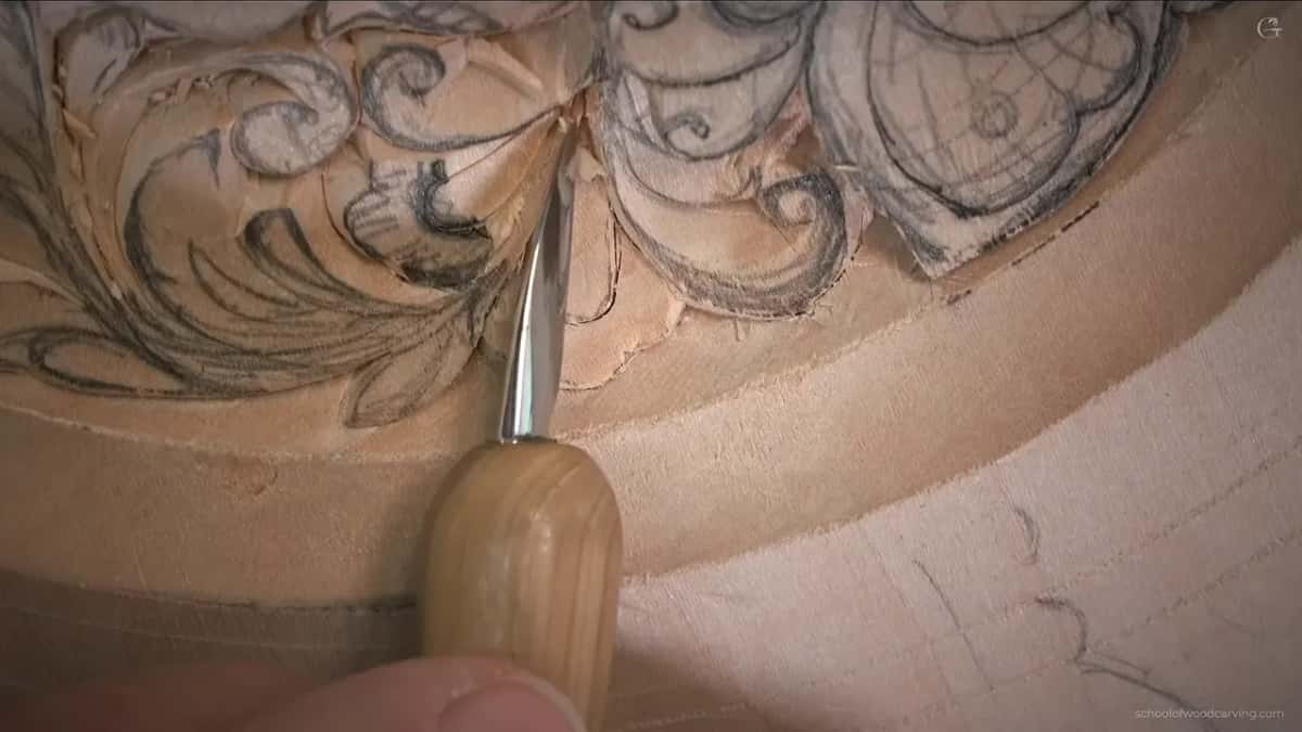 The point of the knife goes down beside a thin stem, right where the design meets the border