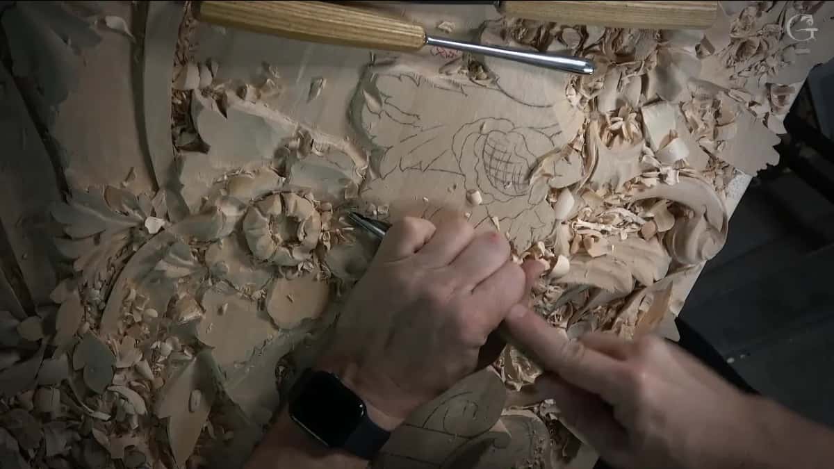 Two gouges resting on the board above working hands