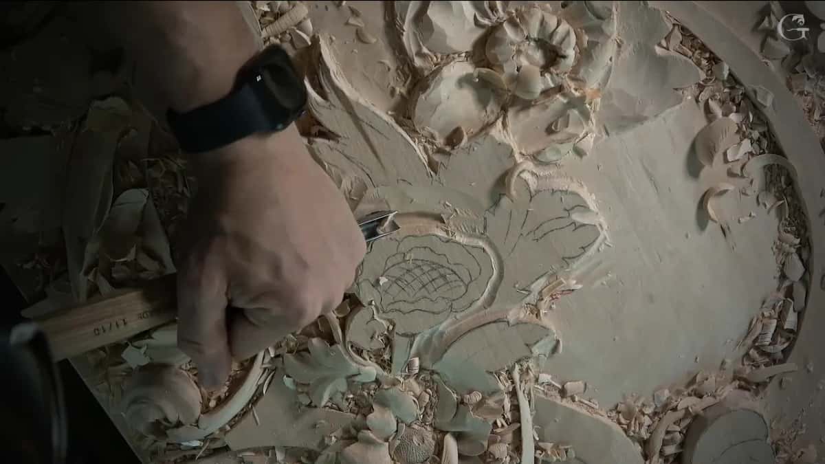 A stamped handle in one fist, its blade down beside the pencil lines of the second bloom