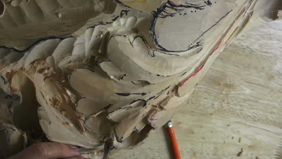 The leaf seen from the side, pencil marks on it and a tool set in the wood below.