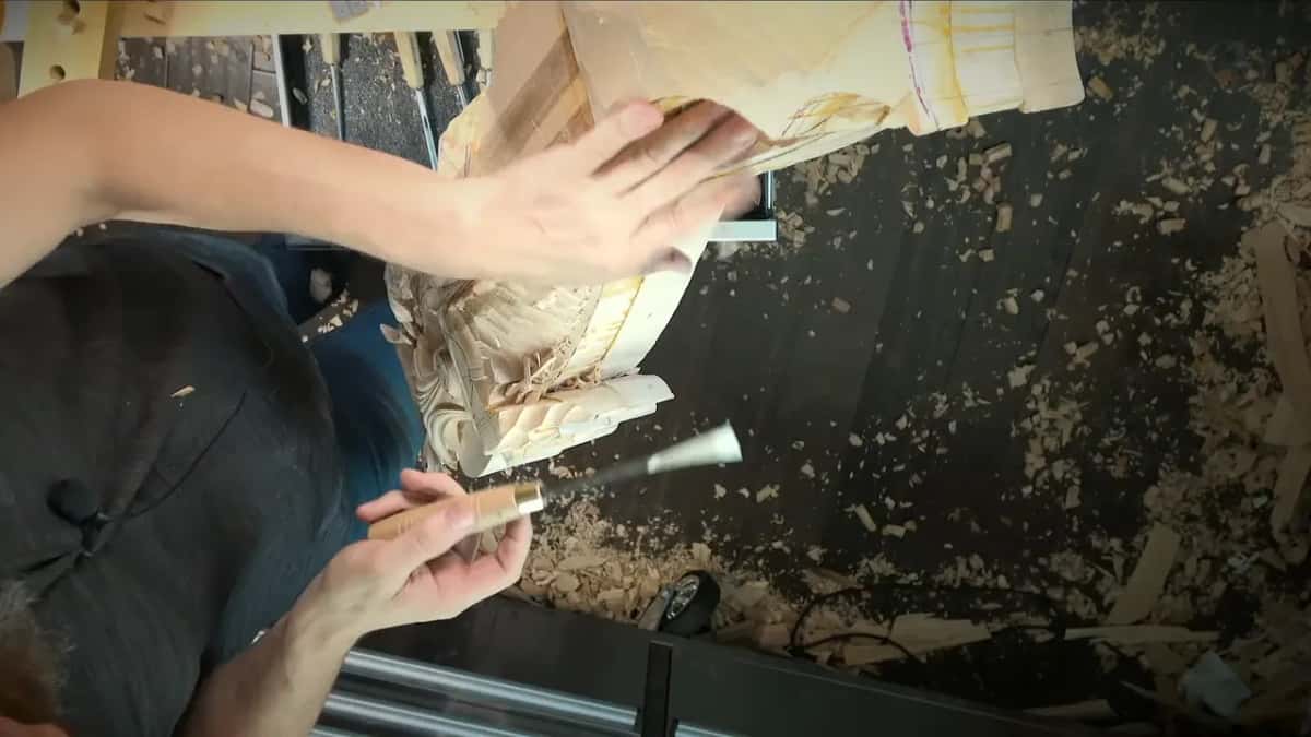 Left hand spread on the side of the corbel while the right holds a gouge ready