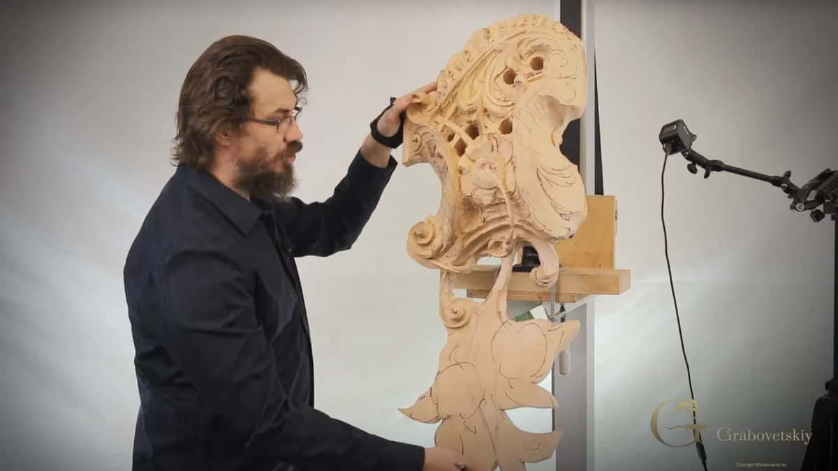 One hand up on the carving where it sits on the platform