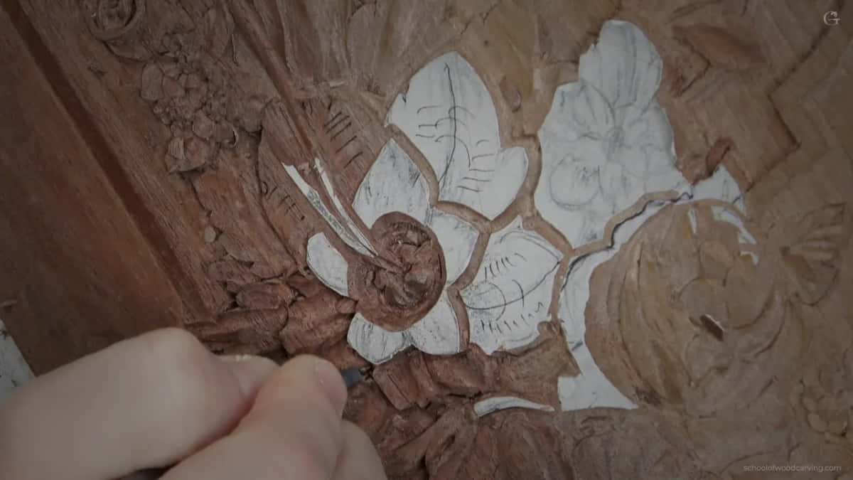 A hand bringing one petal down so its neighbour can throw shade into the joint between them.