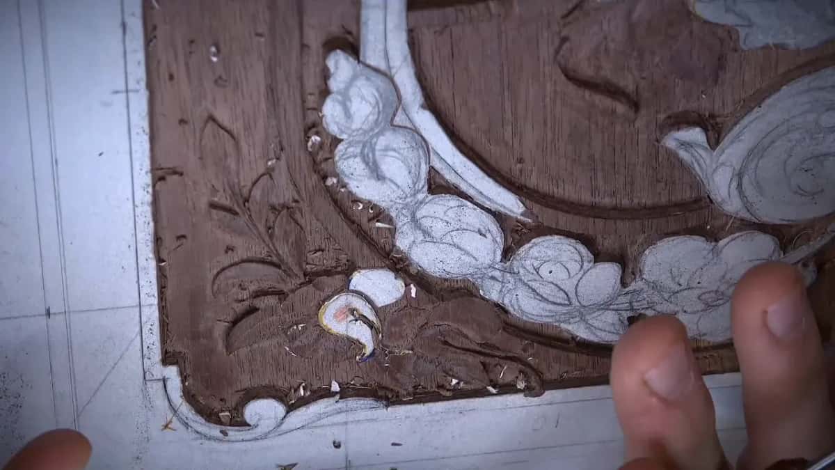 Fingers at the right edge while the corner waits, its small flower still only drawn in marker