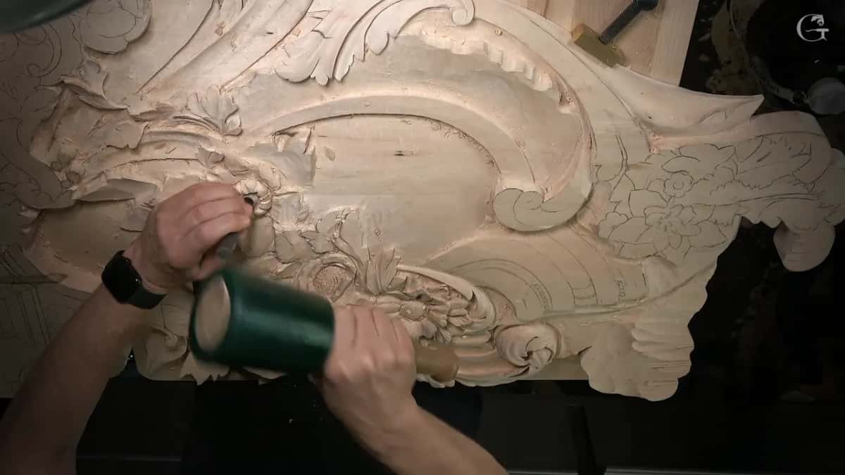 Mallet swung down on a punch at the flower, watch on the wrist, the whole panel in view