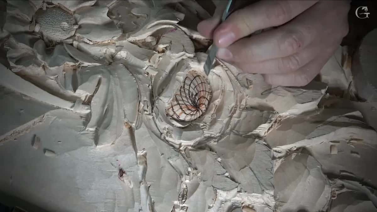 Steel tip coming down at one side of the lined middle, next to the petals, chips here and there