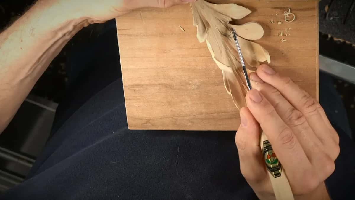Narrow veiner working near the upper lobes while the other hand pins the leaf to the board
