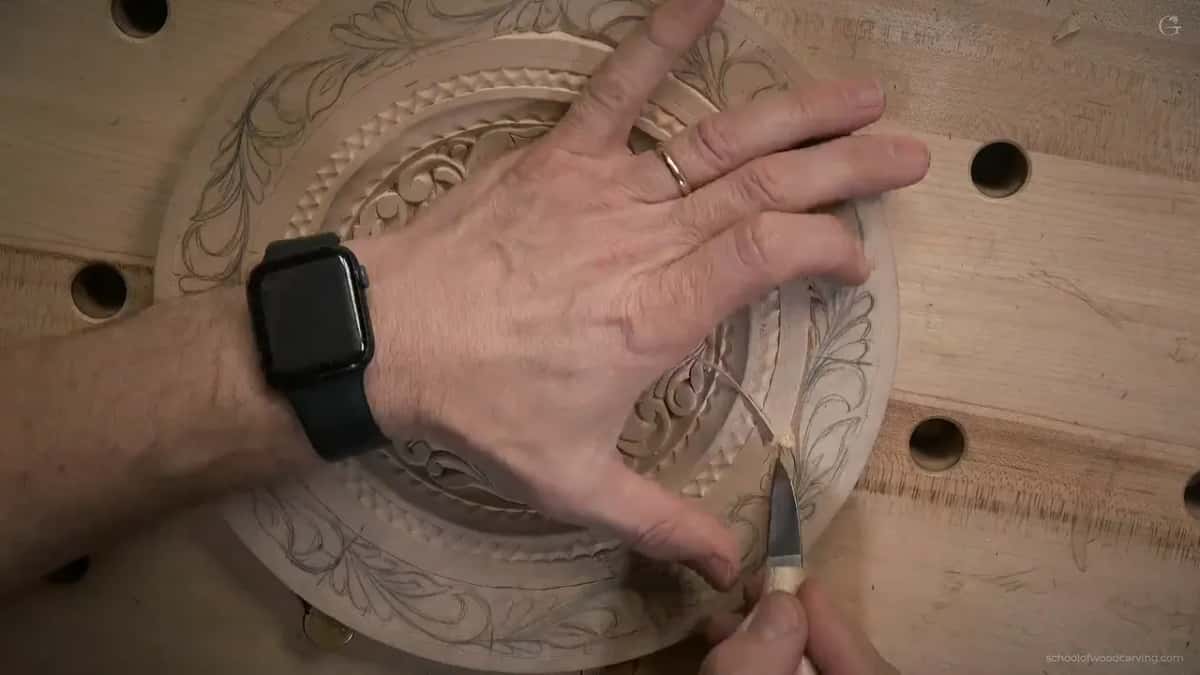 One hand spreads wide while the knife works
