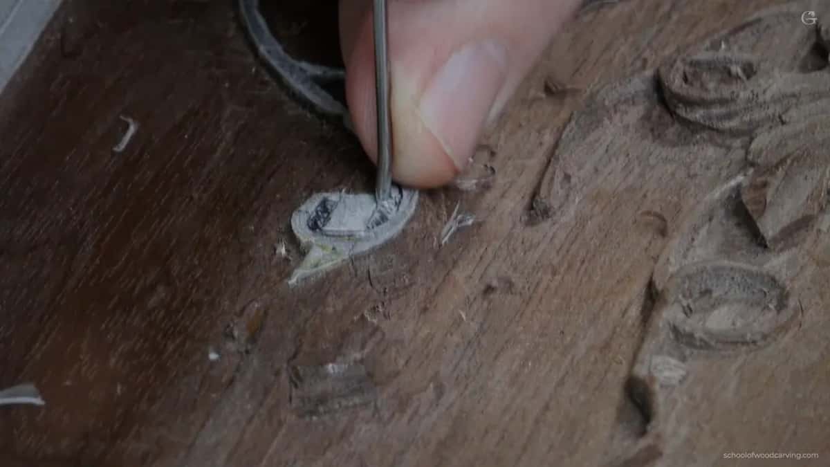 A slim dark tool going straight down beside a small scroll.