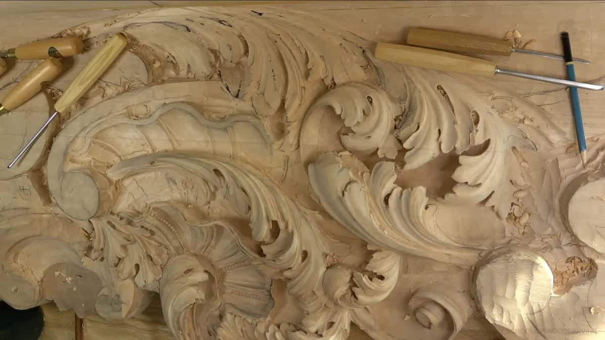 Tools left on the work Five gouges and a pencil left lying on the board beside a long run of carved acanthus