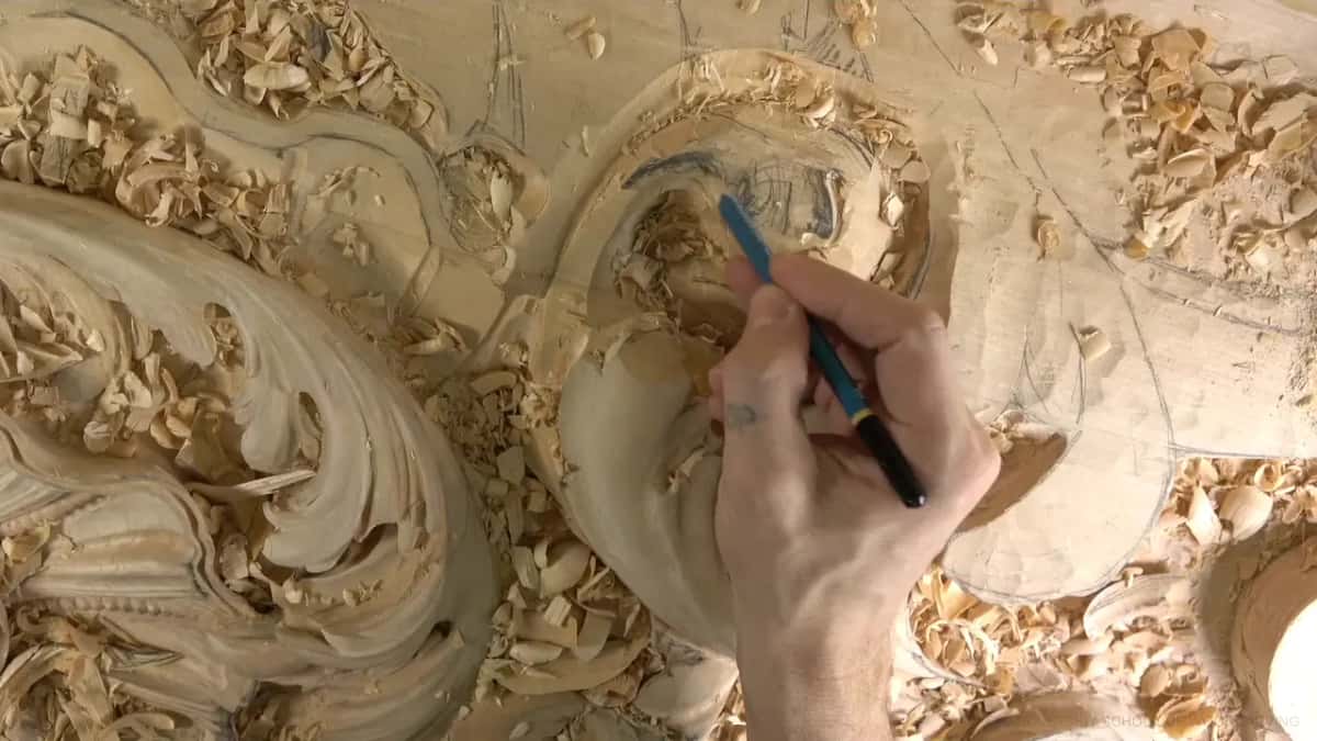 Drawing with the pencil His hand drawing the next detail freehand with a blue pencil