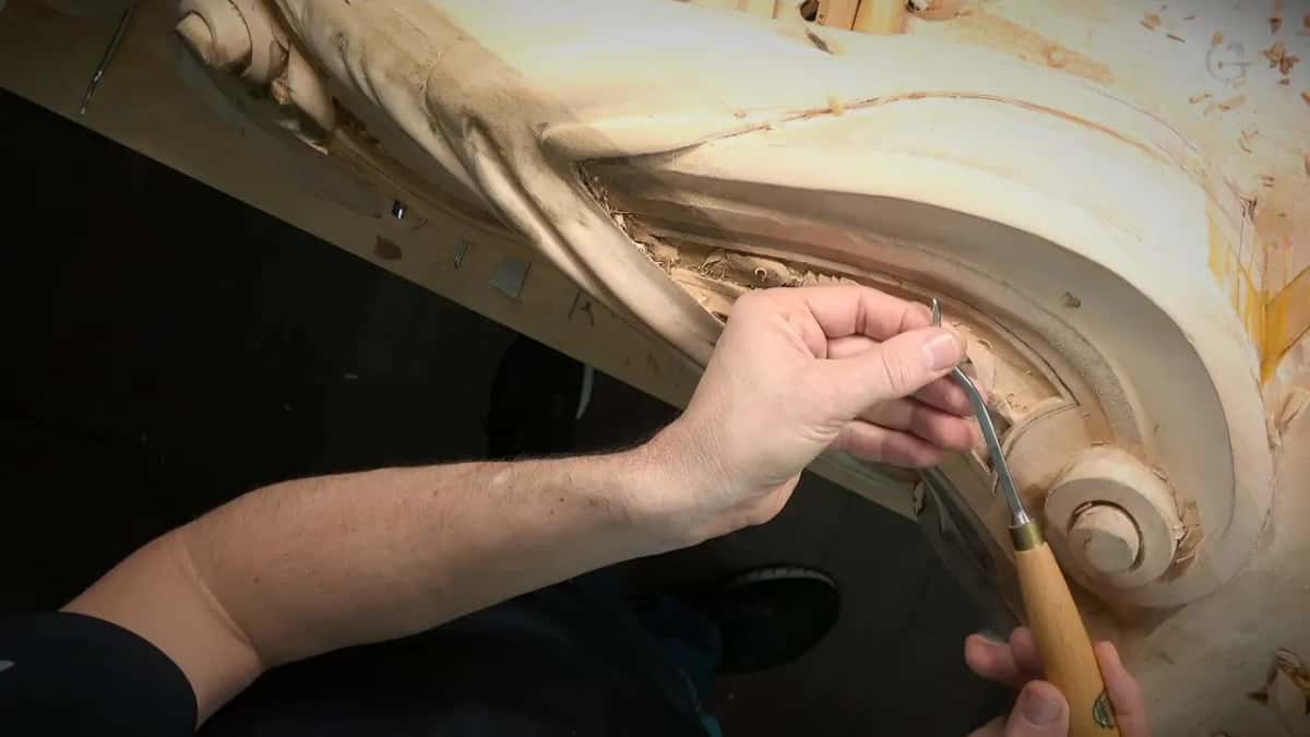 A back bent gouge with a brass ferrule, its bent shank held near the scroll end