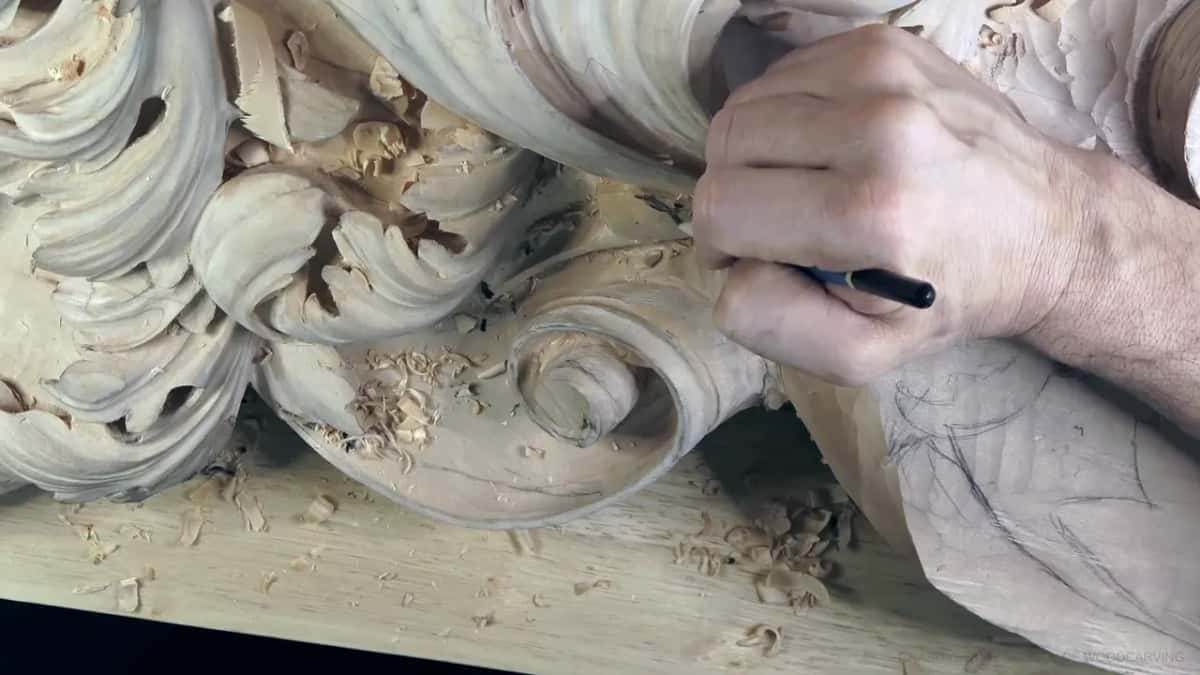 Pencil in hand, sketching on the wood.