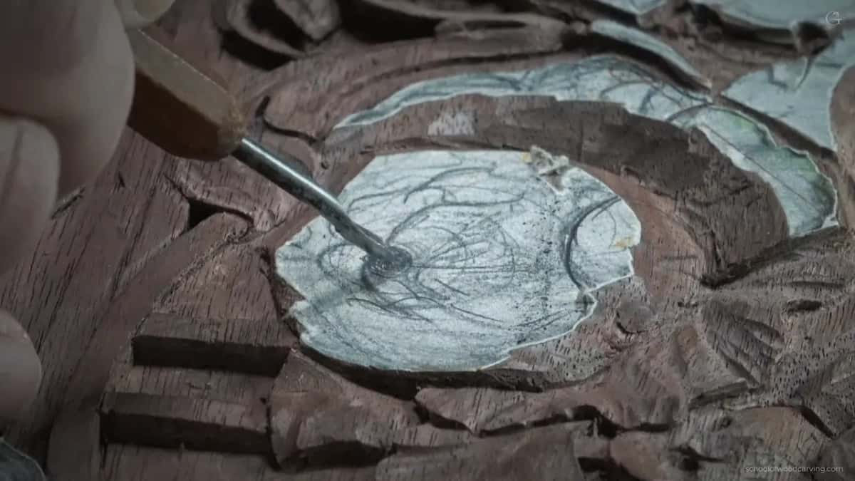 A gouge entering the paper covered middle at a slant, never square into the wood.