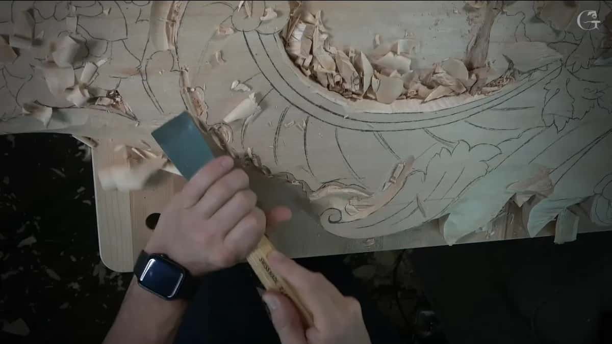 A broad flat gouge clearing the corner while one chip is still flying off