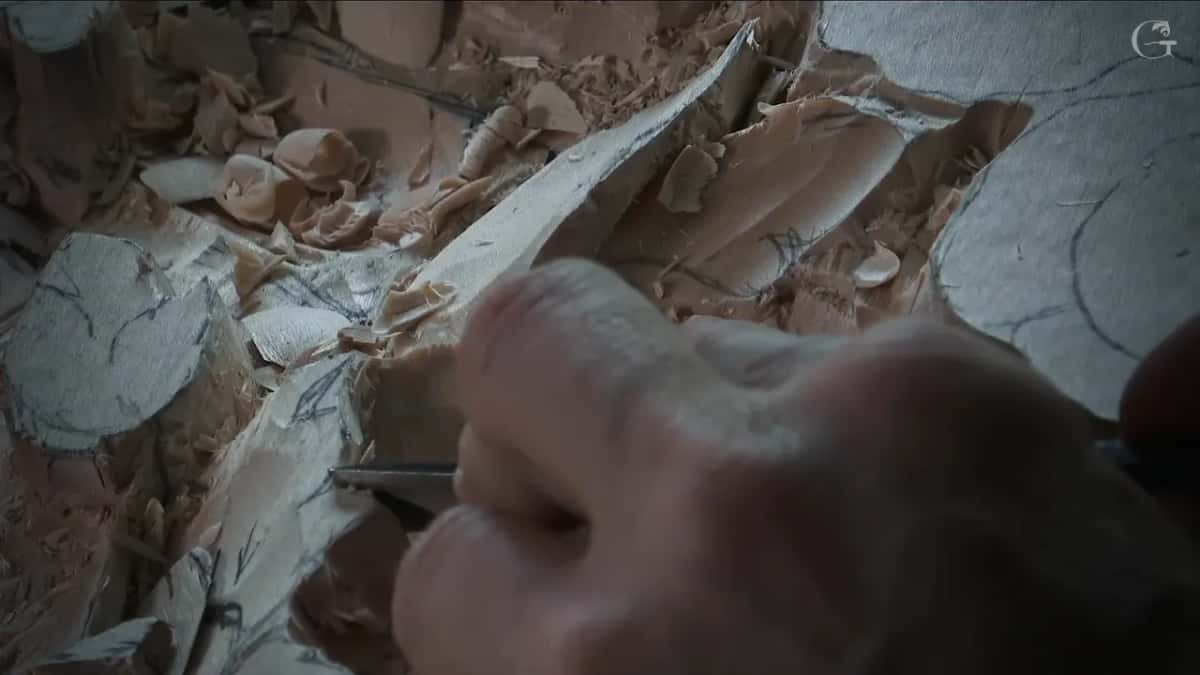 Close view of fingers steering a slim blade along a leaf edge
