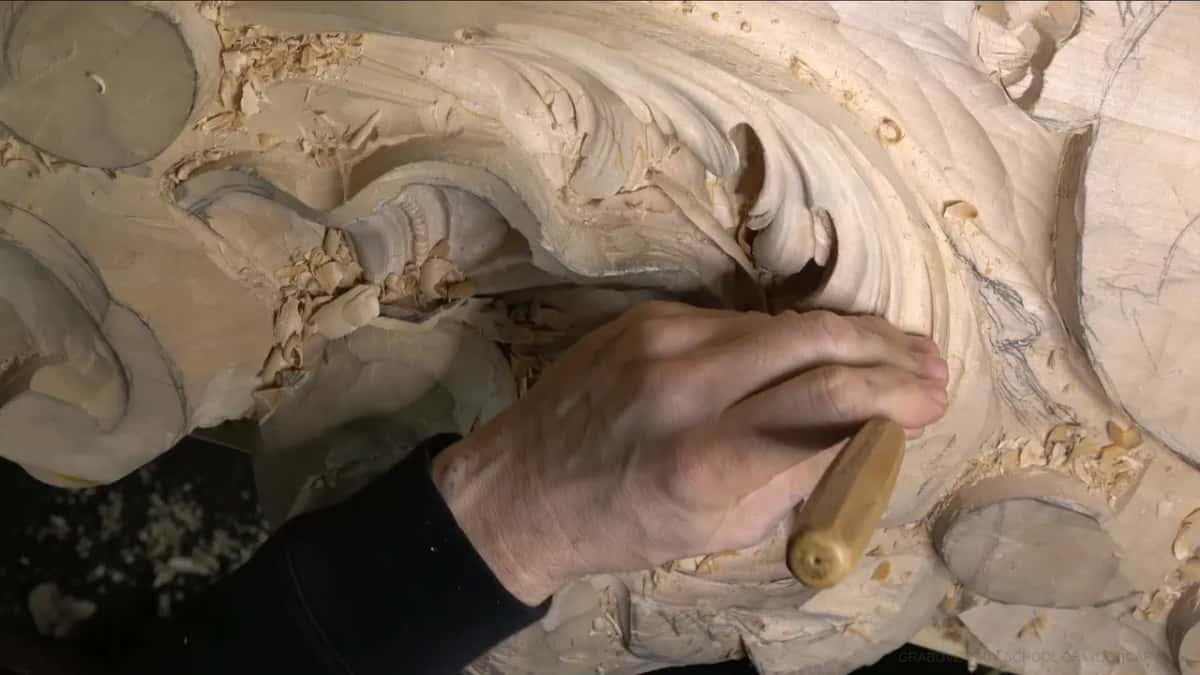 Knuckles over a light handled gouge, digging a pipe as a hollow on the lower lobe.