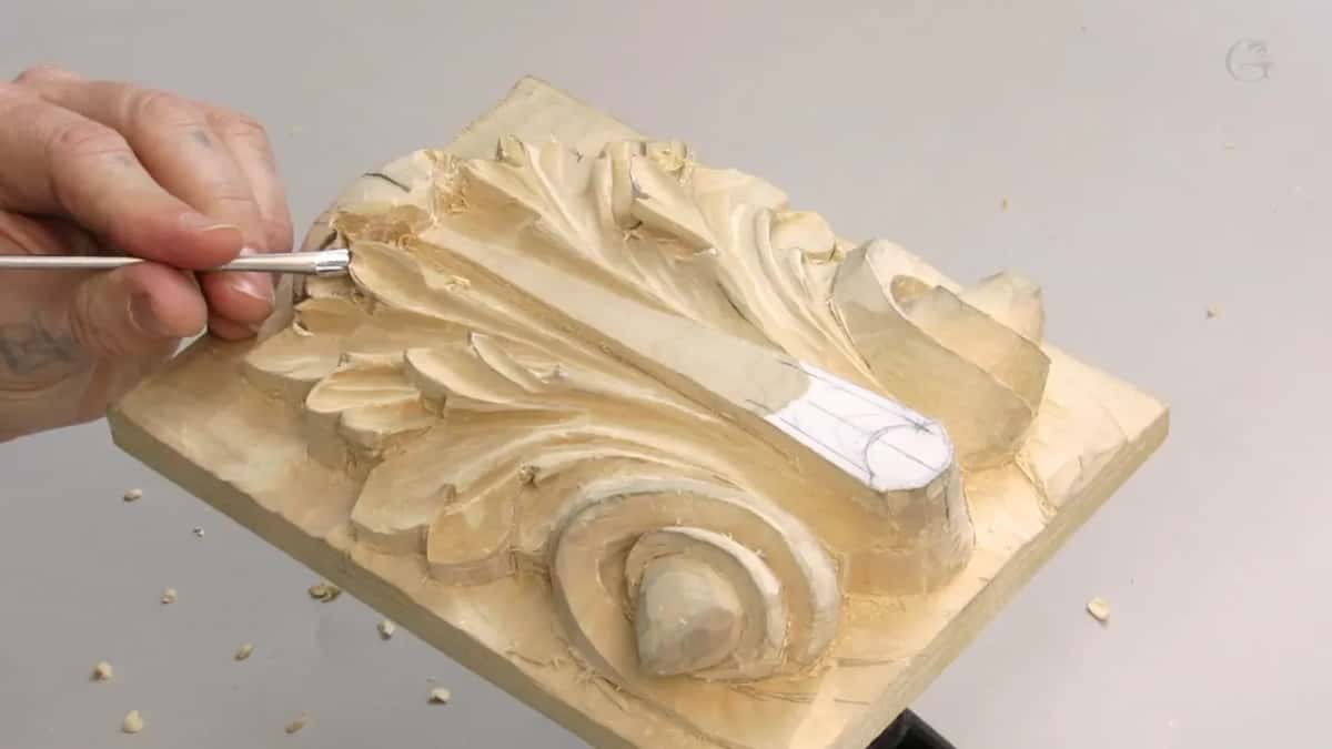 Tighter still, both hands and the tool crowded into the top left of the carving