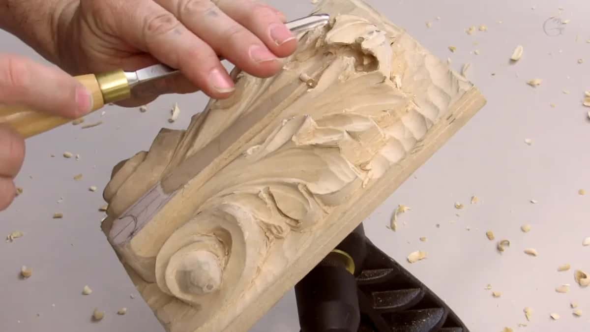 Thumb laid along the blade with a brass ferrule just visible, the tool turning as it travels