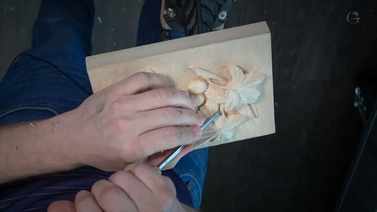Both hands on a narrow gouge along the leaf veins.