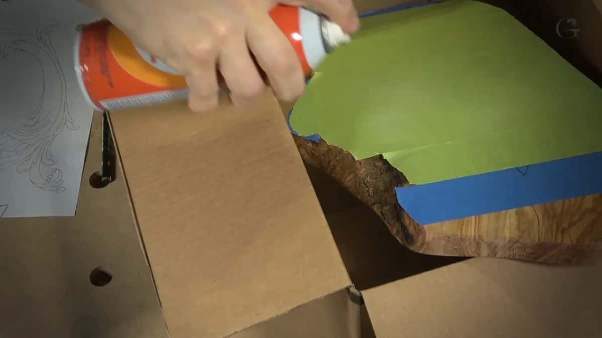 Spraying the glue Spray adhesive goes onto the green tape inside a cardboard box, so it does not get all over the place