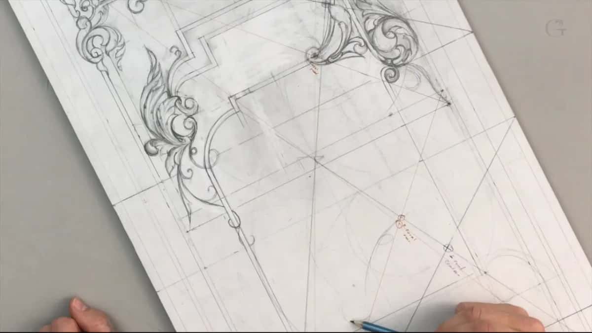 Both hands at the near edge, a pencil tip among lines that carry no ornament yet
