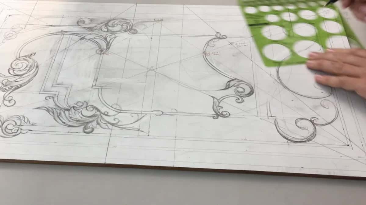 Green circle template held down on the drawing, one hand steadying it
