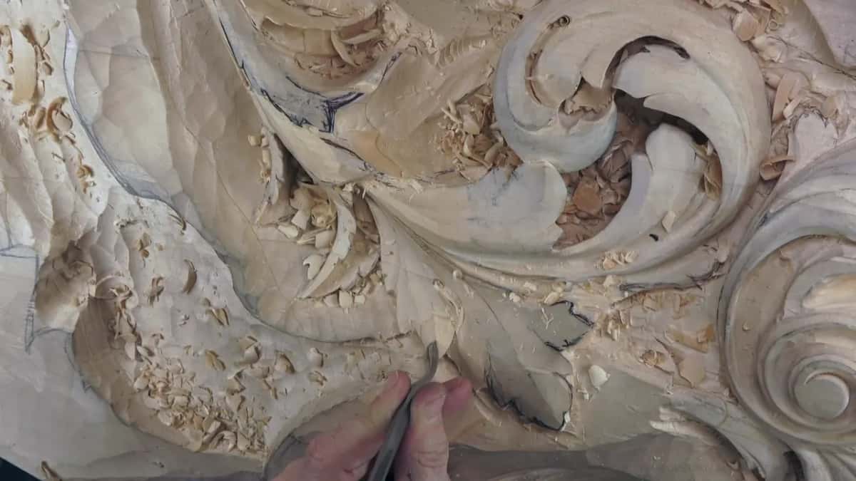 Fingertips and a dark shank at the lower lobe, working in under its edge.