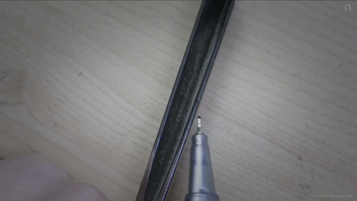 Close view along a V tool with a marker tip beside one wing showing uneven thickness