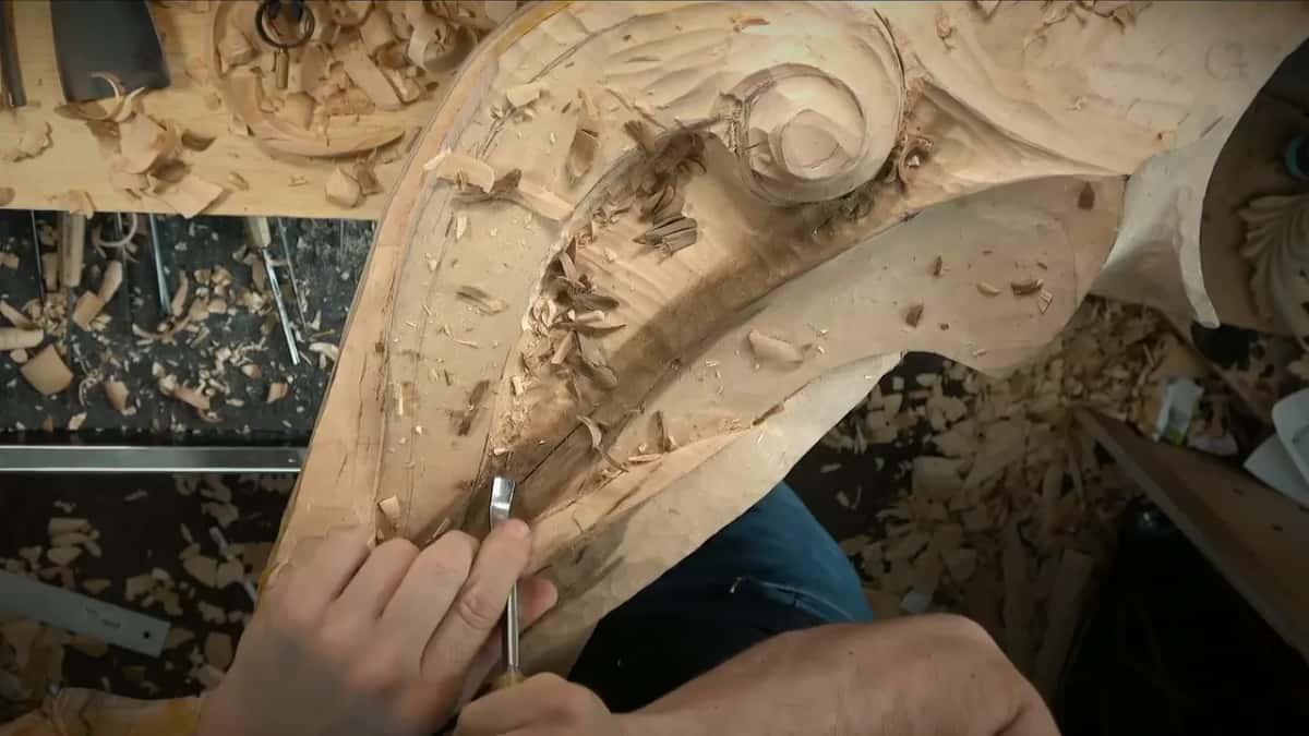Short gouge held low in the curved hollow, fingers close to the edge