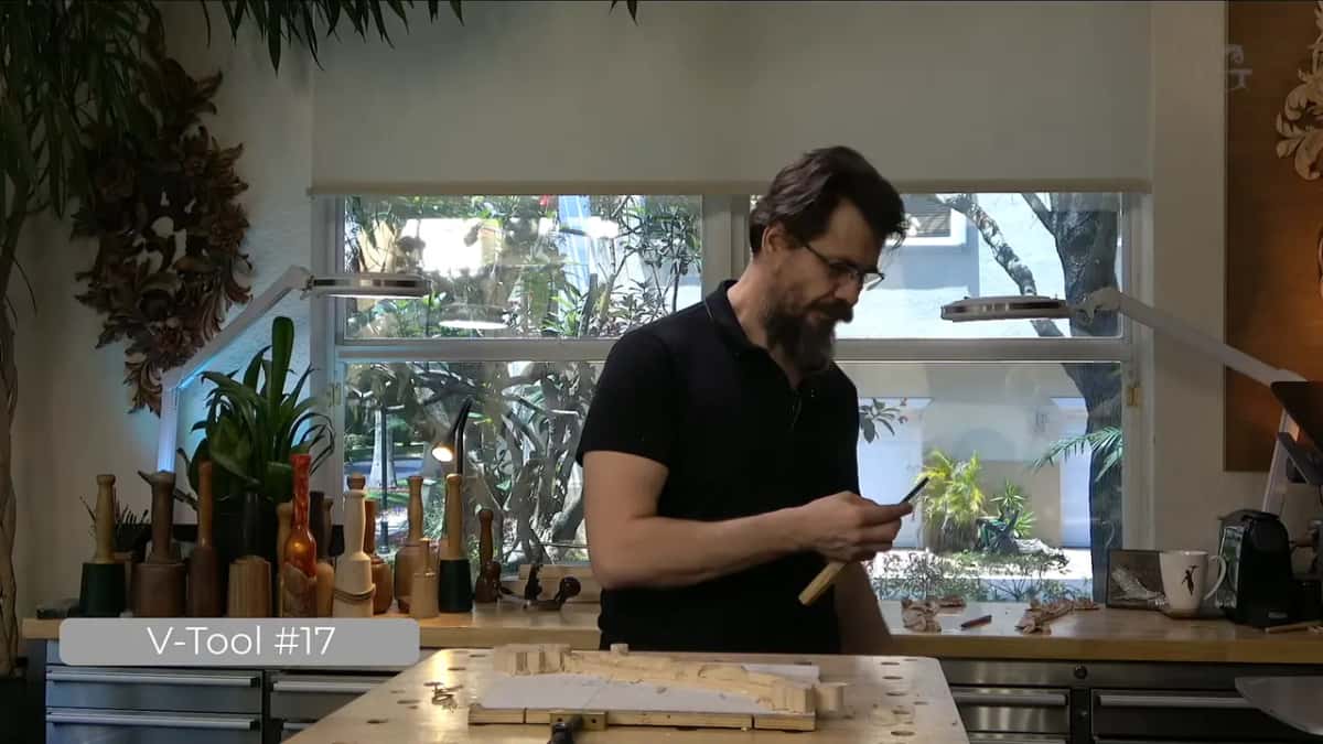 Holding the six millimetre tool up at the bench.
