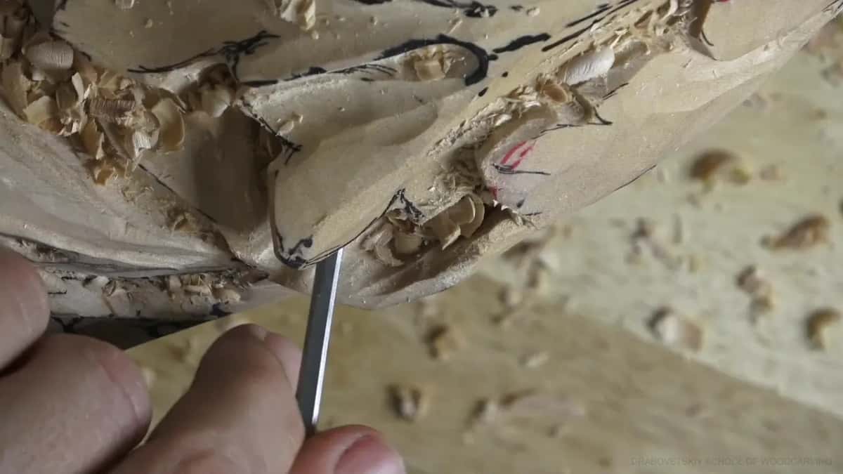 Thin blade underneath Very thin blade slid in beneath an edge, with red and black layout marks showing on the wood