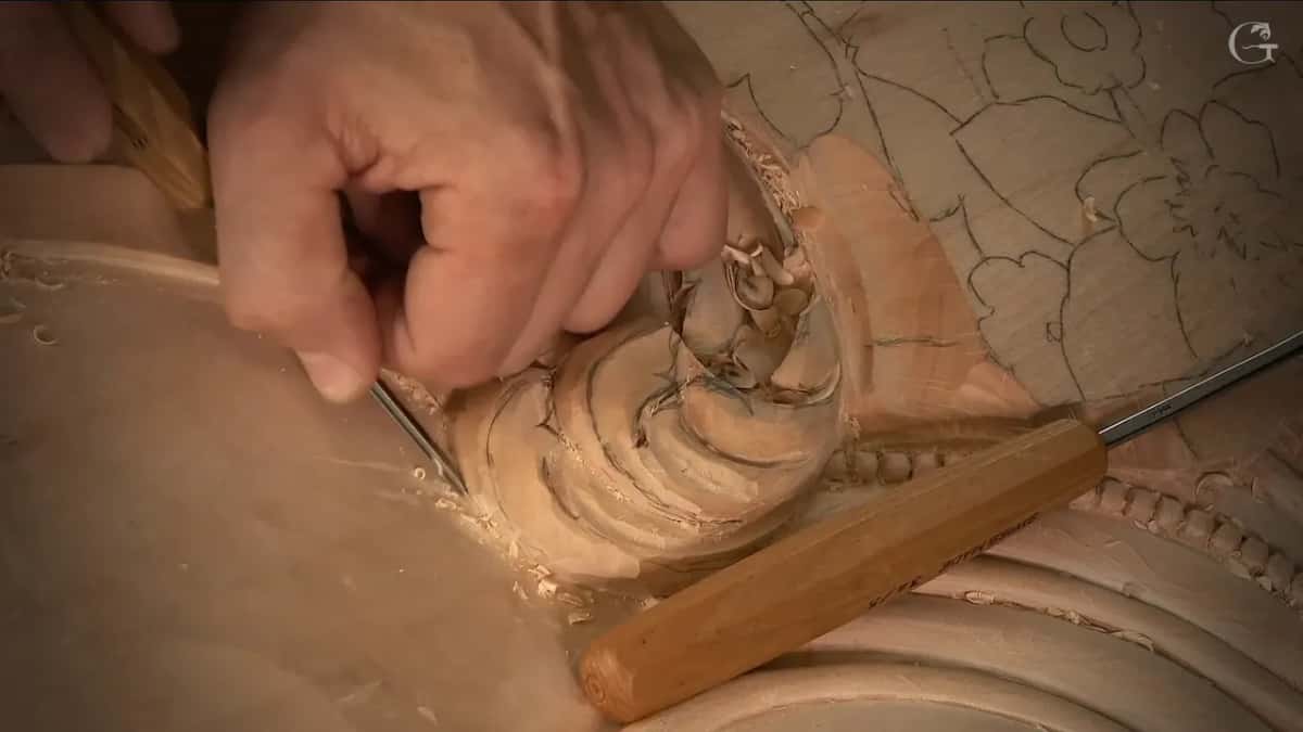 A second gouge waits on the panel