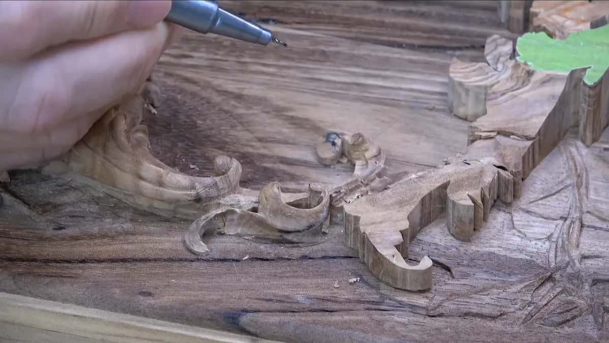 Olive layer from a low angle, both scrolls in view, a slim silver pen held above them