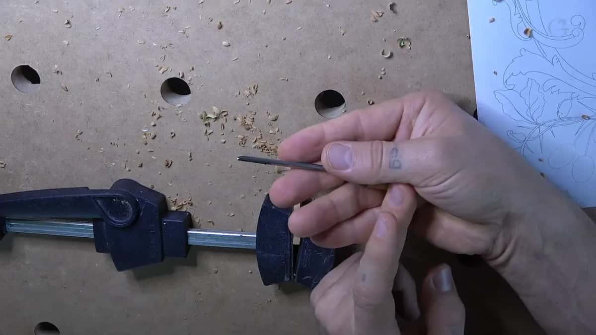 Palm tool held upside down, its short handle hidden in the hand and only the steel showing