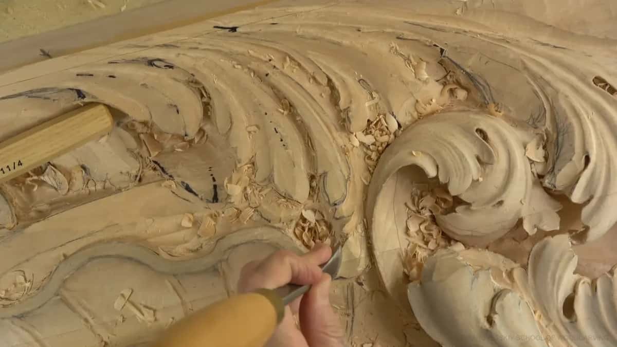 Small gouge, pale handle, low near the curl.