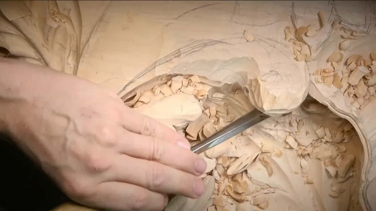 Left hand steering a long blade in under the lump, chips everywhere below it