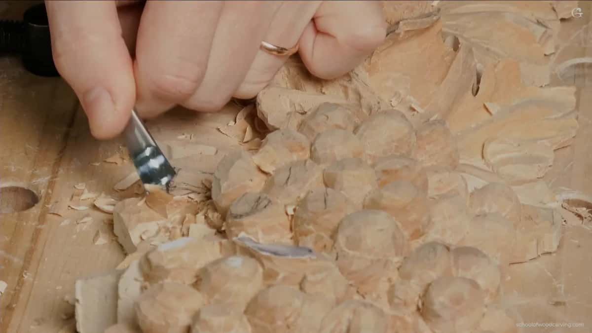 Fresh chips curling off as the blade rolls the first motion into a lobe above the fruit