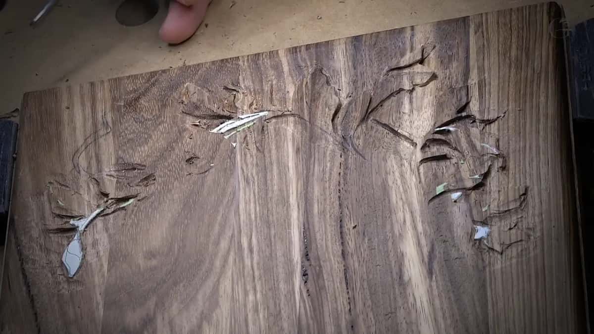 Seen from above partway through the layer: carved leaves on the right, pencil lines still waiting on the left.