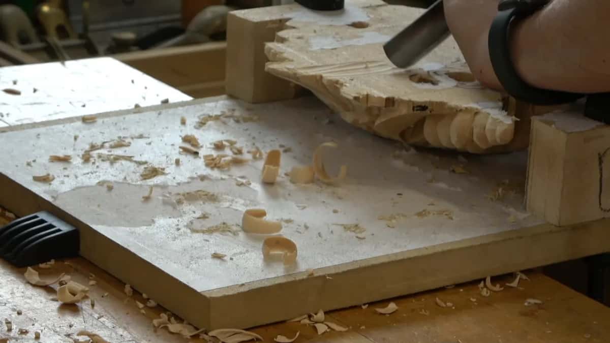 Gouge opening the reverse, curled chips coming away in long shavings that drop onto the bench