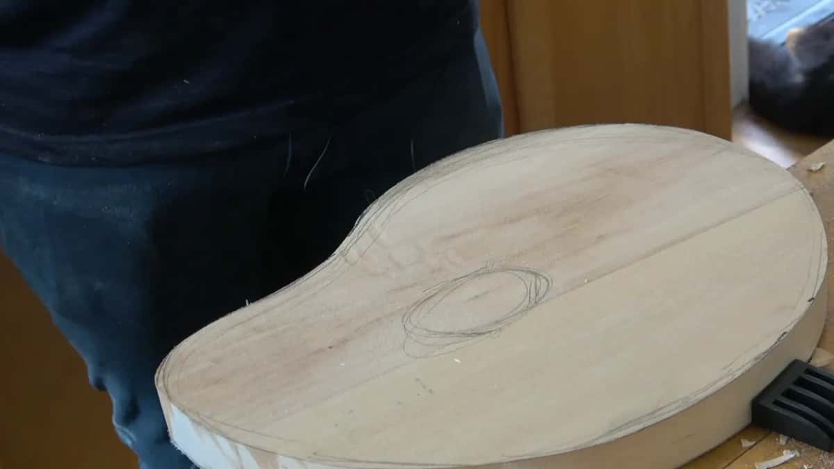 Background board with a pencil oval drawn on it, and faint layout lines running across the surface
