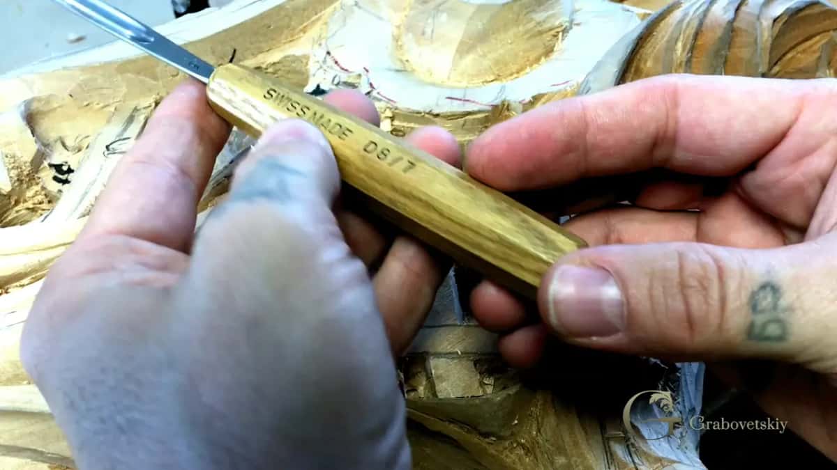 Pale octagonal handle stamped Swiss Made, the blade working in a carved panel.