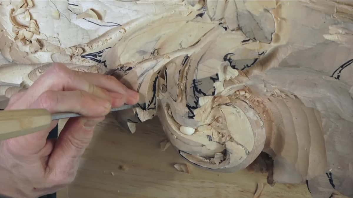 Cutting to the line One hand pushing a gouge into the drawn edge of the dome, its marker lines being carved away as he goes