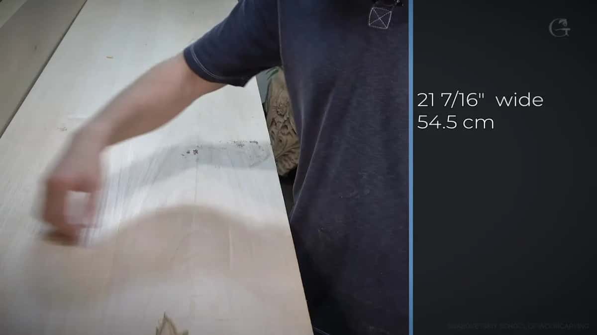 Twenty one and seven sixteenths His hand flat on the board, the caption on screen reading 21 and 7/16 inches