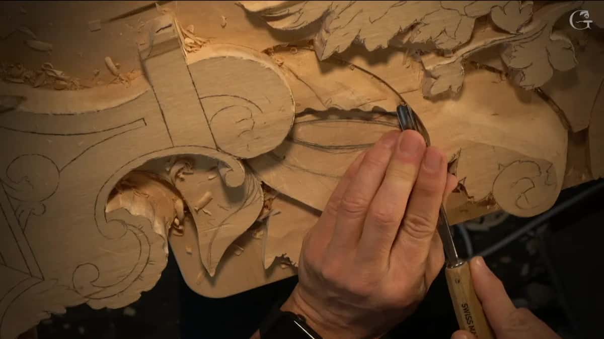 Fingertips steady a small gouge on the wavy top line of the ray.