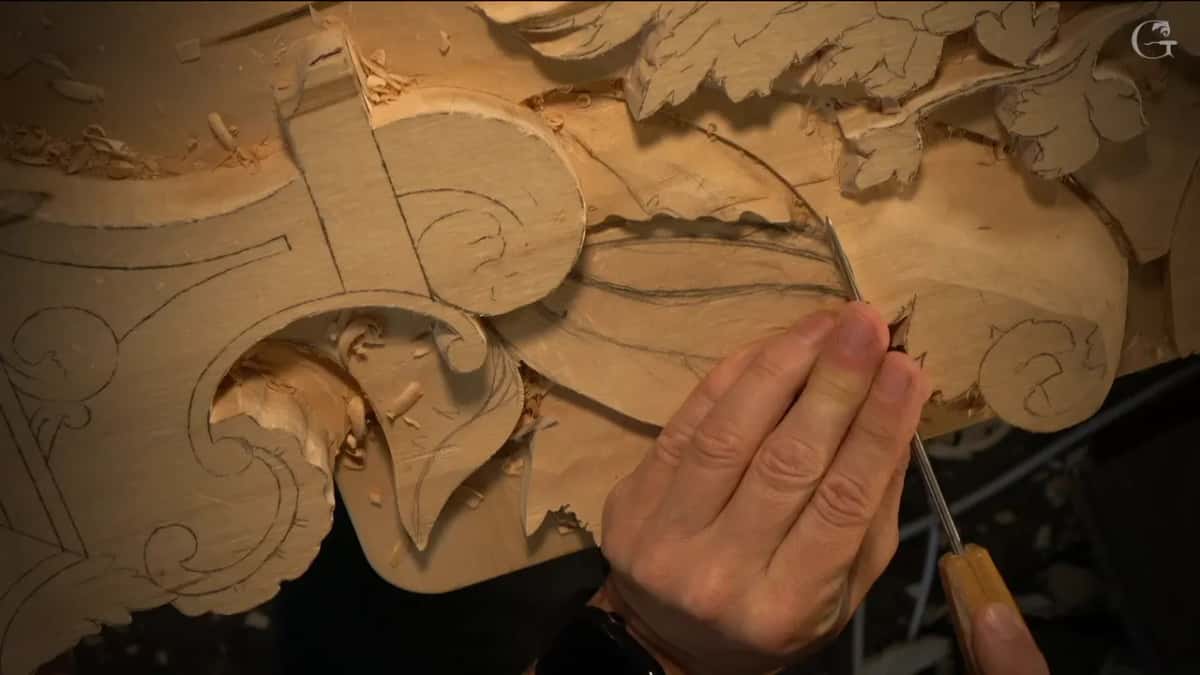 By hand now, a very thin blade rides that top line under his fingertips, with pencil lines still on the ray.